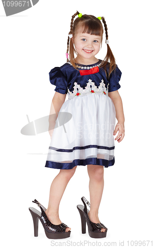 Image of Funny little girl in her mother's big shoes