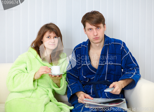 Image of Couple sit on sofa and watching TV in disgust