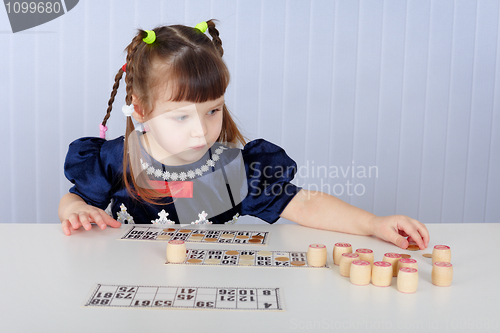 Image of Little girl playing with lotto sitting at table