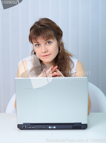 Image of Young beautiful woman sits with big laptop