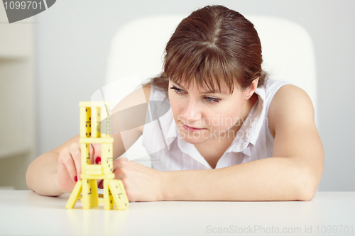 Image of Girl is focused to build a tower with domino on table