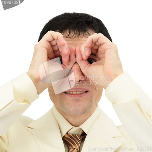 Image of Businessman looking through fingers like a pair of binoculars