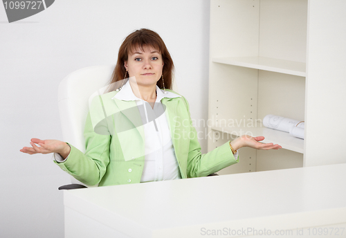 Image of Woman sitting at table alone and upset helpless gesture