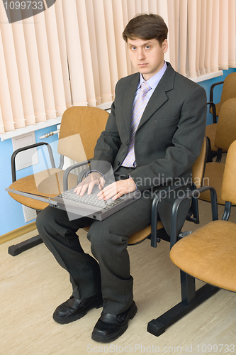 Image of Person in a suit with the laptop