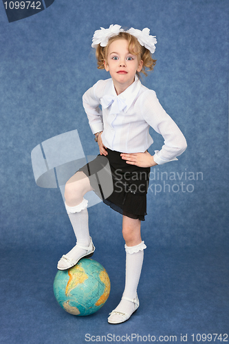 Image of Girl set foot on globe like a soccer ball