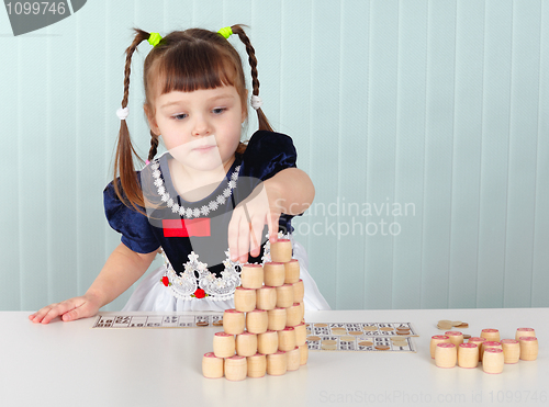 Image of Little girl builds tower of lotto