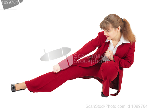 Image of Woman in red business suit kicks