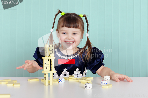 Image of Little happy girl is playing with toys