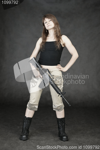 Image of Woman armed with American rifle standing on black