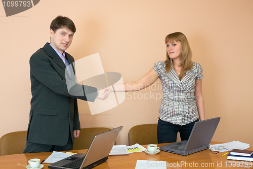 Image of Greeting of young businessmen at office