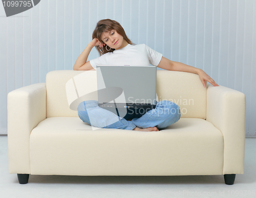 Image of Beauty is sitting on sofa with laptop