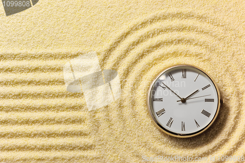 Image of Old watch on surface of golden sand
