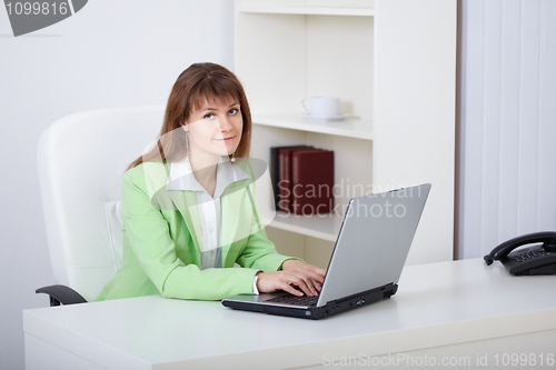 Image of Beautiful girl works at office with computer