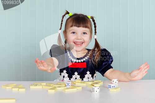 Image of Happy beautiful child plays with toys on table