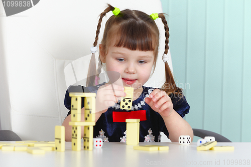 Image of Child playing with dominoes at table