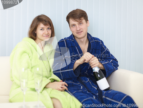 Image of Young happy couple drinks sparkling wine