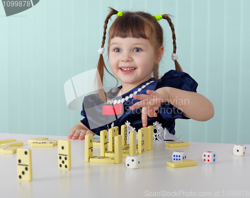 Image of Cheerful child playing with small toys at table