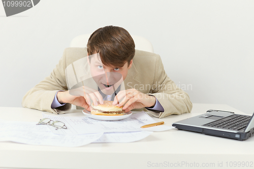 Image of Hungry businessman eats tasty sandwich