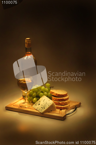 Image of wine, grapes, cheese and bread in the night