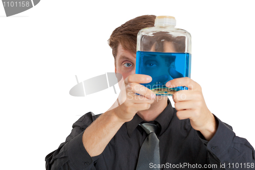 Image of Man checks physical properties of liquid in bottle