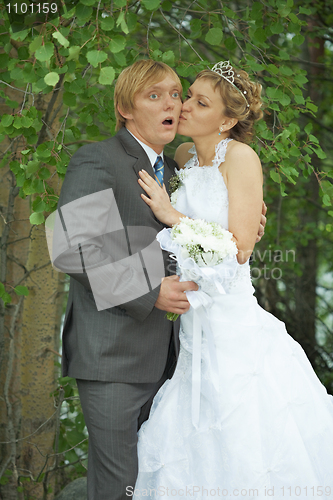 Image of Amusing groom and bride kiss secretly