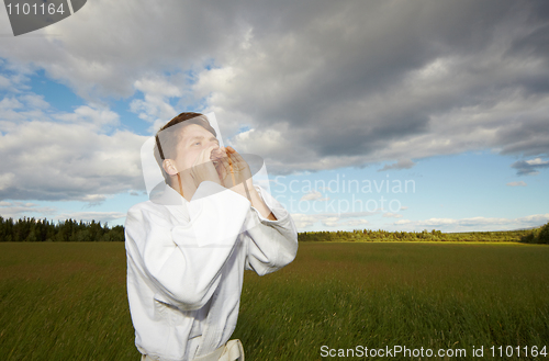 Image of A man shouting into field