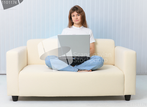 Image of Beauty is sitting on couch with laptop