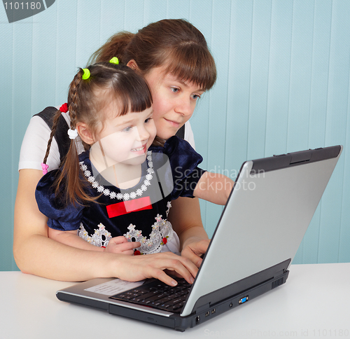 Image of Mother and daughter playing with laptop