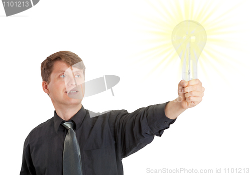 Image of Young man lit by bright idea in form of electric light