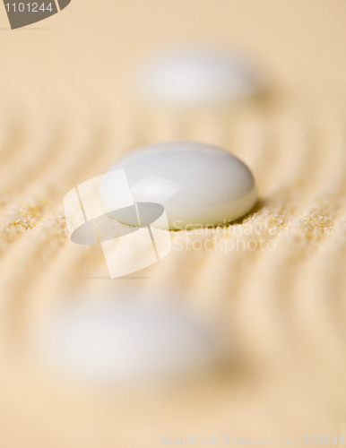 Image of White pebbles on yellow sand closeup