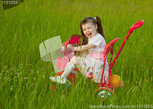 Image of Cheerful little girl goes on a bicycle