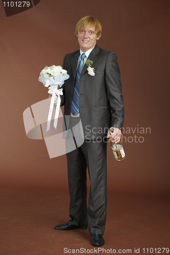 Image of Groom with bouquet and bottle of sparkling wine
