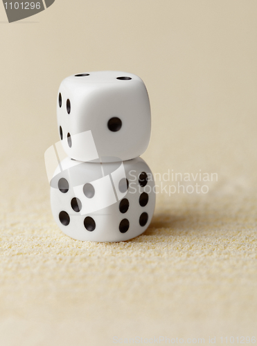 Image of Two dice on yellow sand