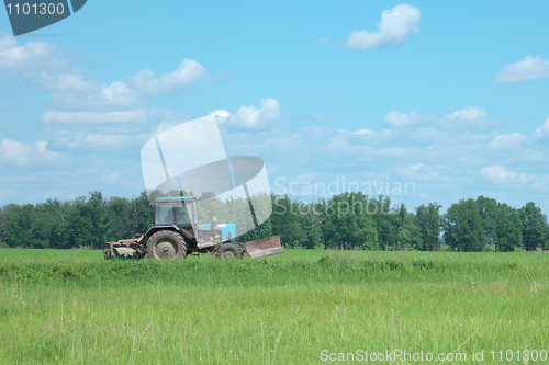 Image of Old tractor goes through field