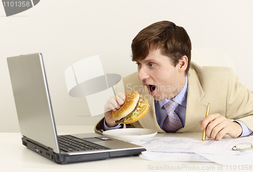 Image of Young businessman is going to eat sandwich
