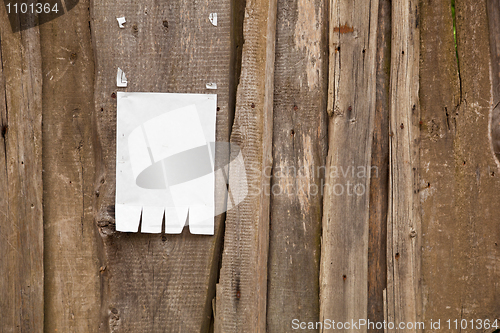 Image of Paper ad on wooden fence