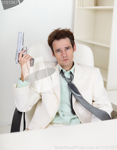 Image of Young, strong-minded businessman with gun in hand
