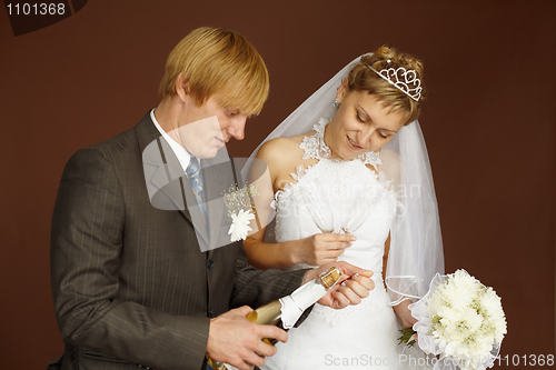 Image of Couple opens a bottle of sparkling wine