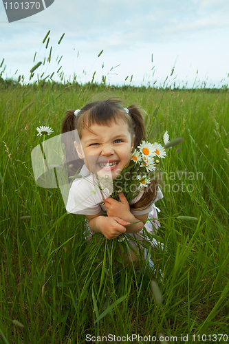 Image of Cheerful child embraces wild flowers