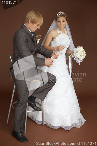 Image of Amusing bride scaredly waits for popping champagne