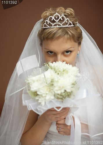 Image of Portrait of bride with bunch of flowers at face