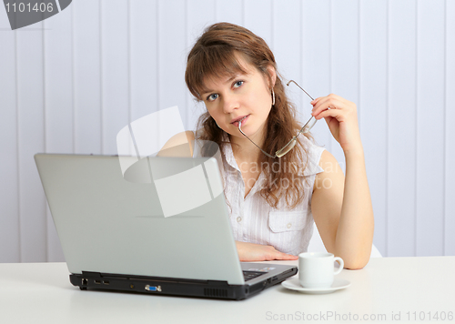 Image of Beautiful young girl at table with laptop