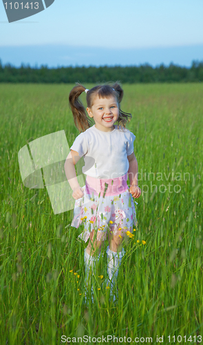 Image of Happy child jumps on green grass in field