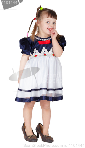 Image of Little beautiful smiling girl in mother's shoes