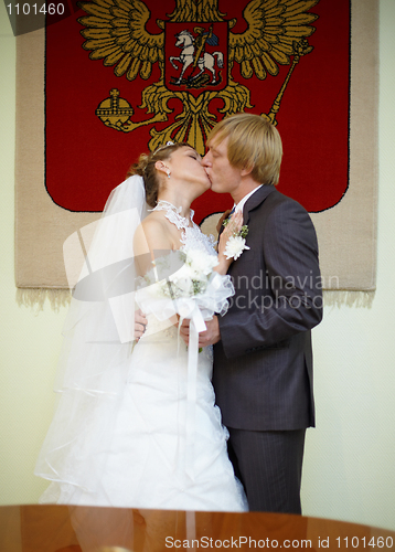 Image of Newly married kiss under Russian arms