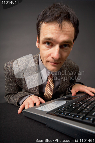 Image of Amusing portrait of man on workplace at dark office