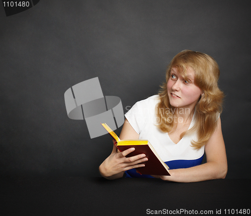 Image of Amusing girl with book in dark