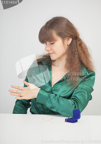 Image of Girl admires a jewel on finger