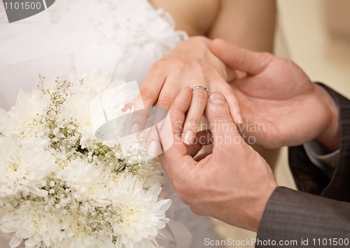 Image of Hands of groom and bride with ring close up