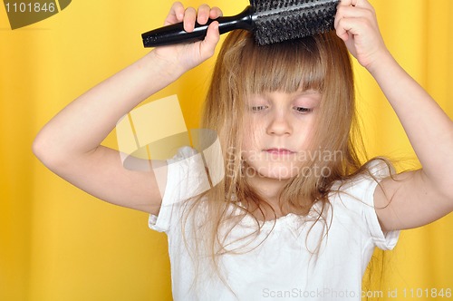 Image of child brushing her hair